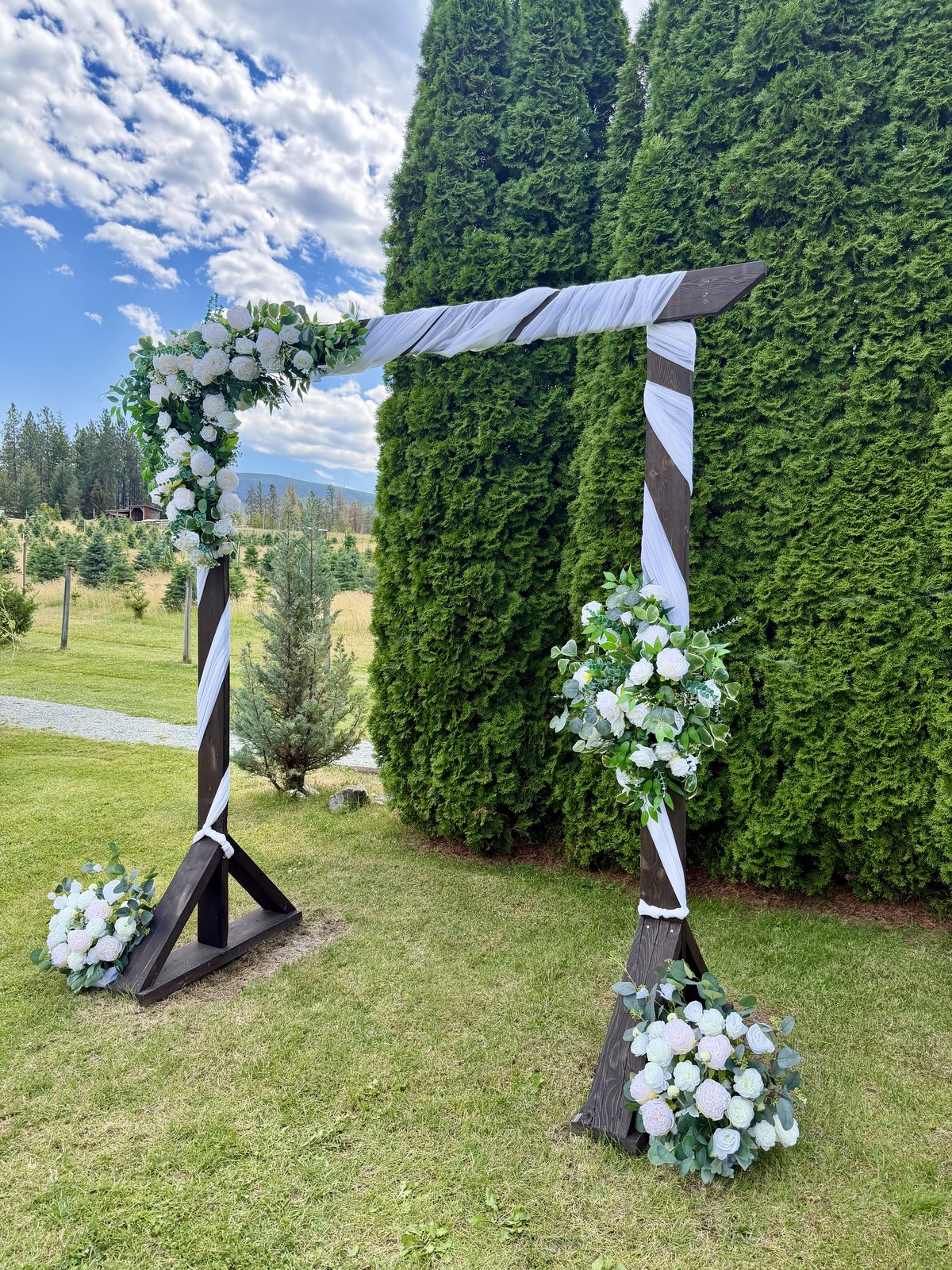 White roses, peonies and eucalyptus on the wedding ceremony arch — Meadow Vista Honey Wines, Kelowna