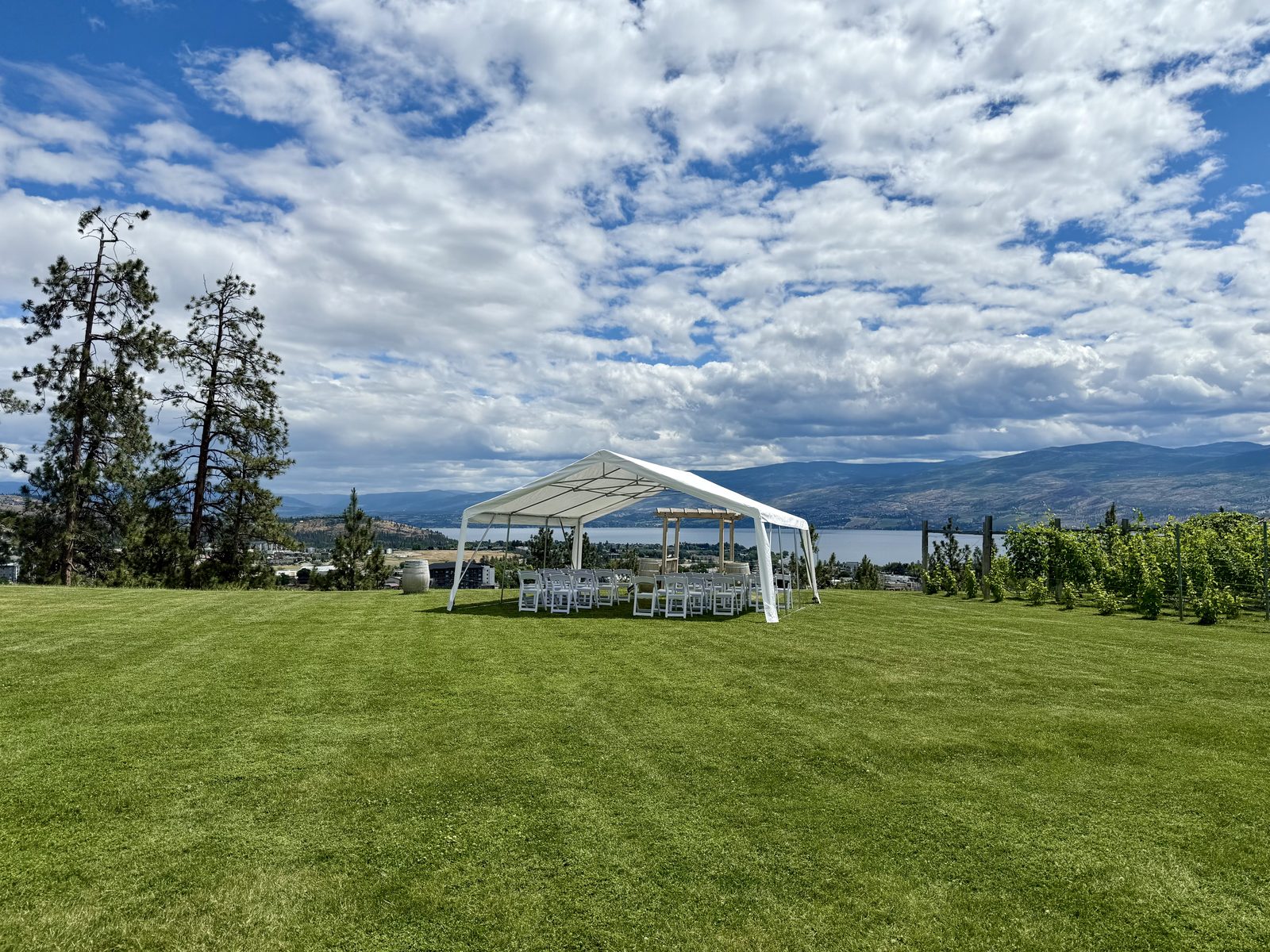 White frame tent wedding at Off The Grid Organic Winery, West Kelowna, with Okanagan Lake views